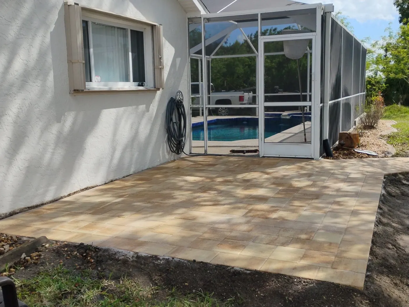 After: new paver patio beside the pool enclosure